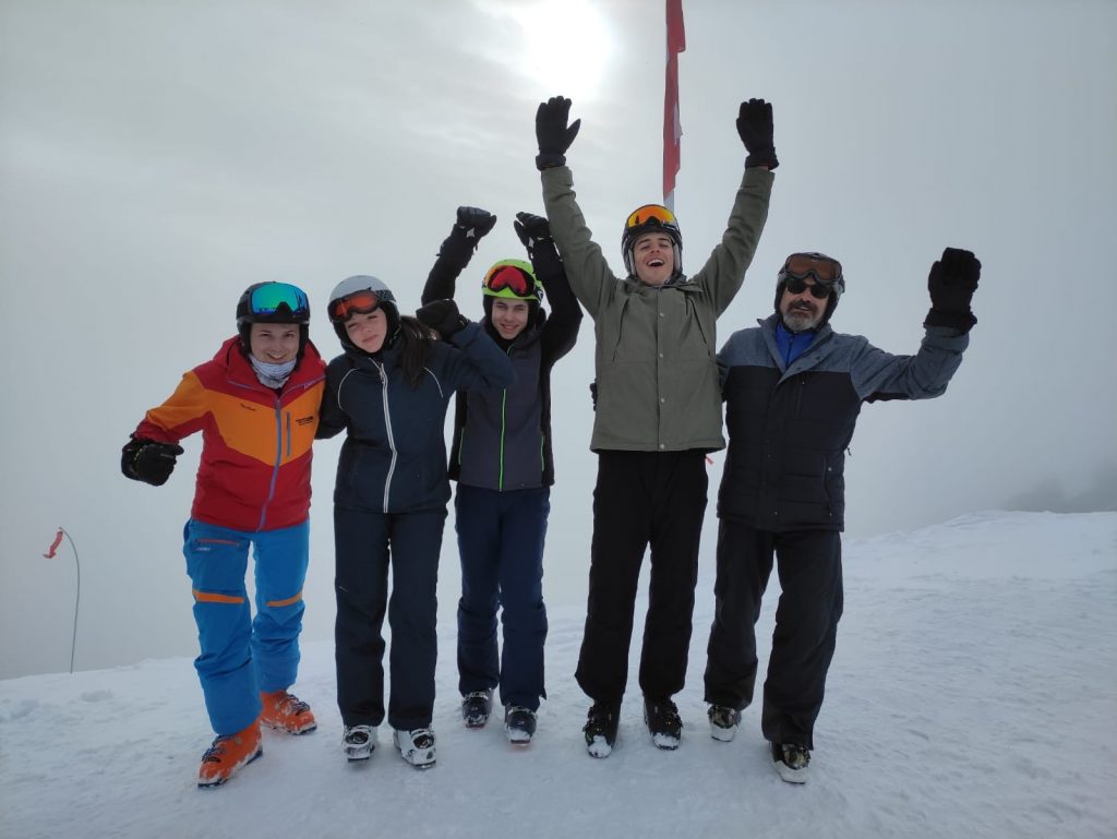 Skizunft-Gruppe auf der Piste, Arme in der Luft